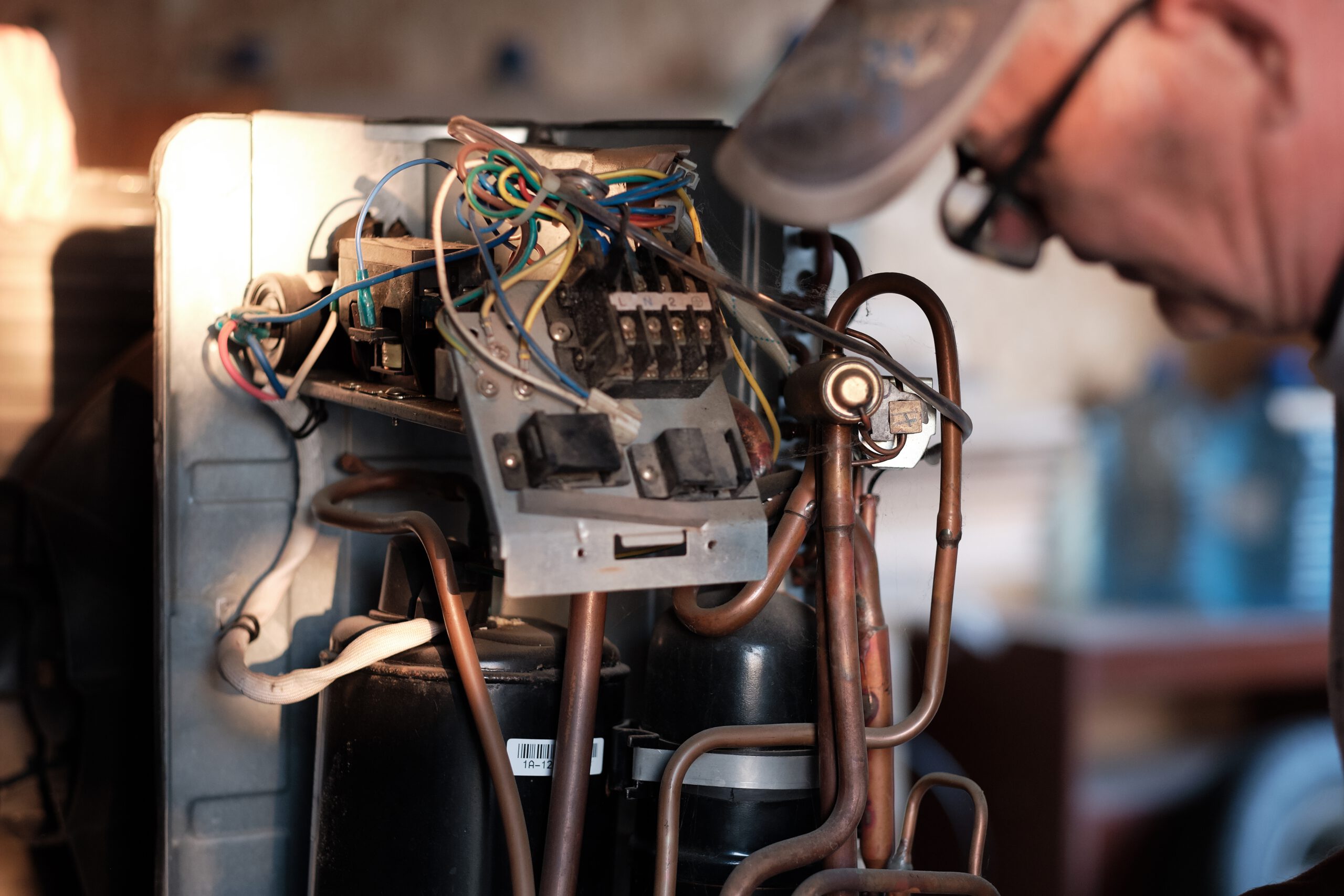 Fresno HVAC technician inspecting air conditioner components during a heat pump service call